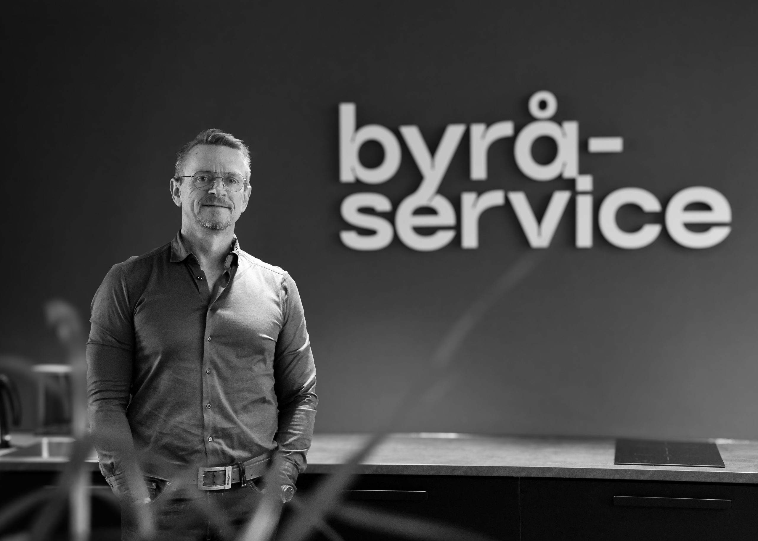 Erik foran Byråservice skilt